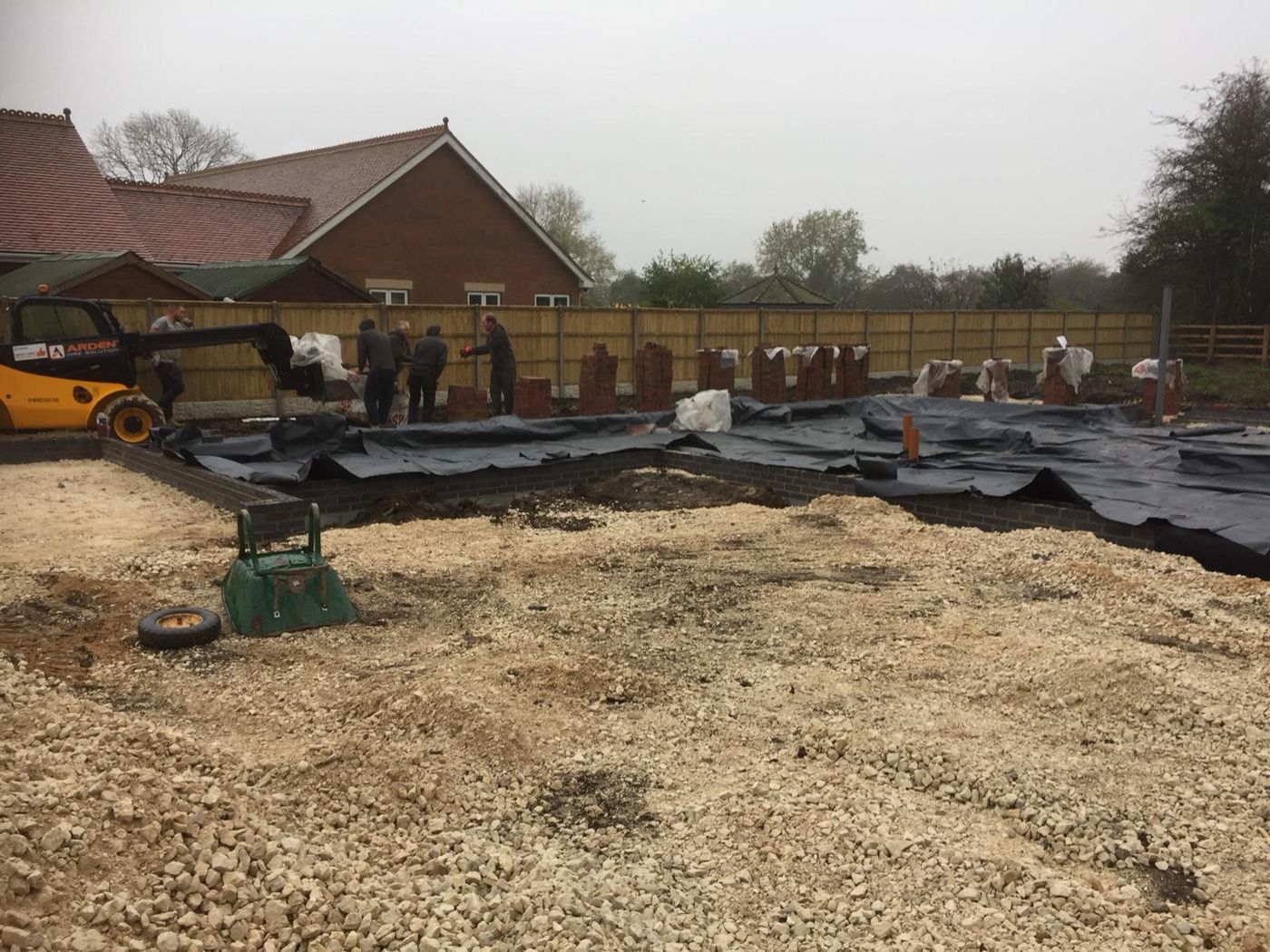Foundations and ground-floor slab complete, with bricks loaded out