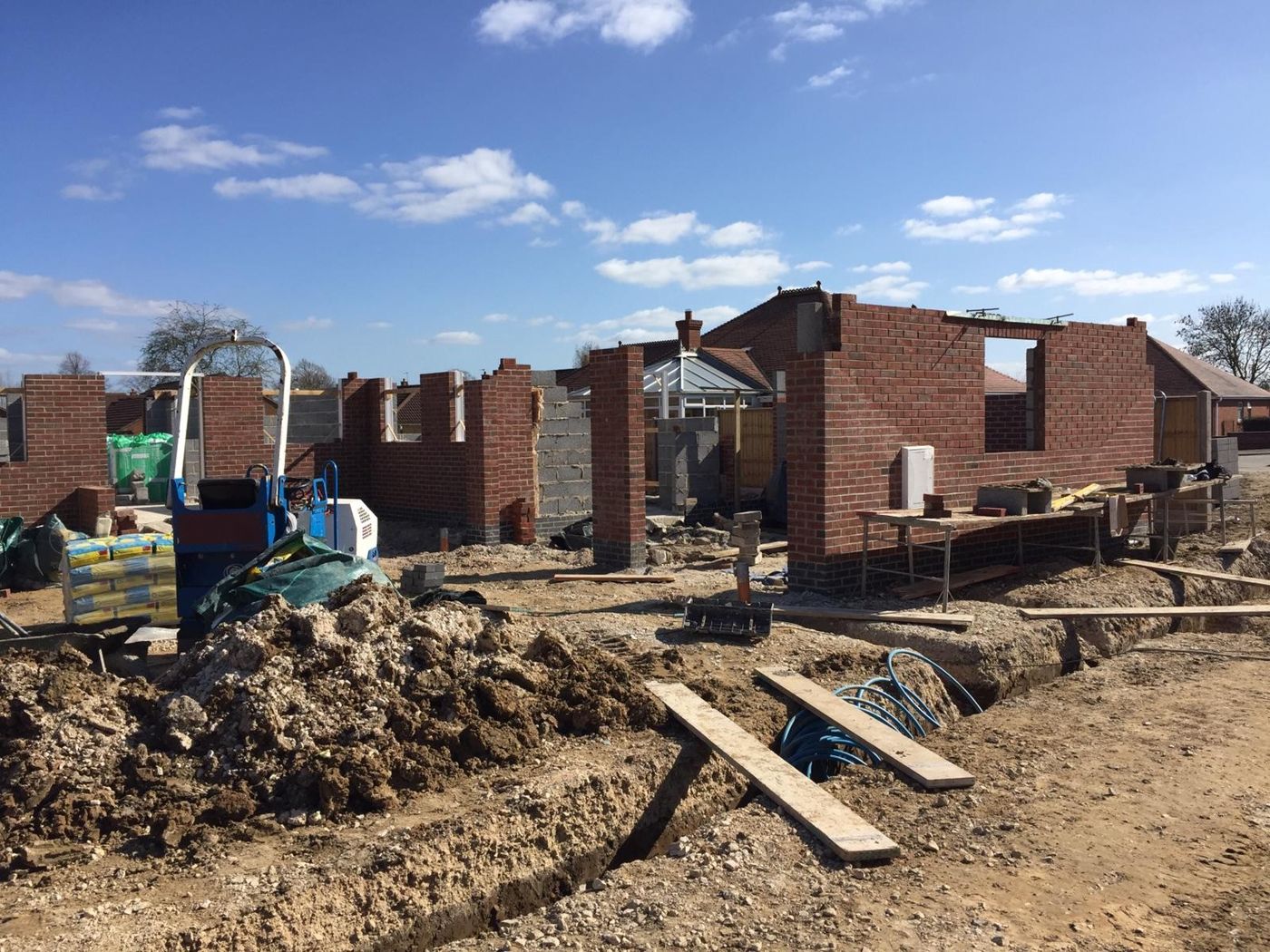 Brick walls of the bungalows rising above the damp-proof course