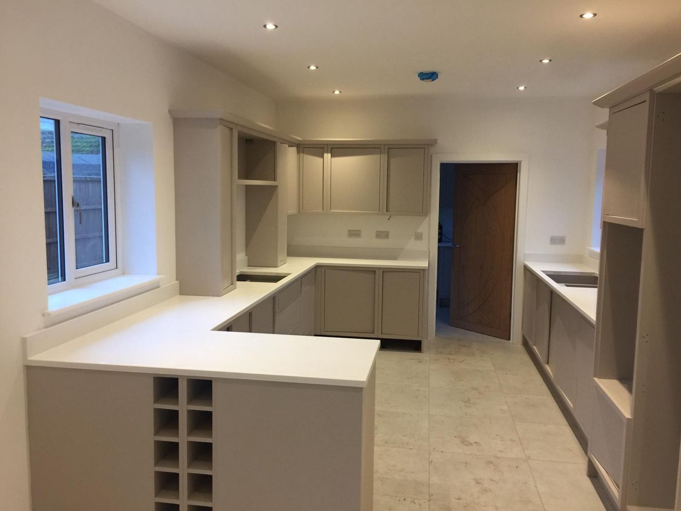 Shaker-style kitchen with white worktops being fitted