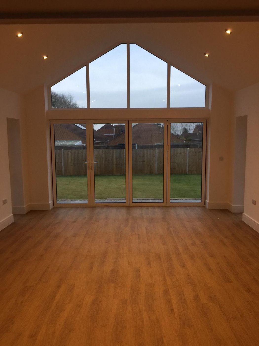 Living room with a glazed gable and bi-fold doors to the garden